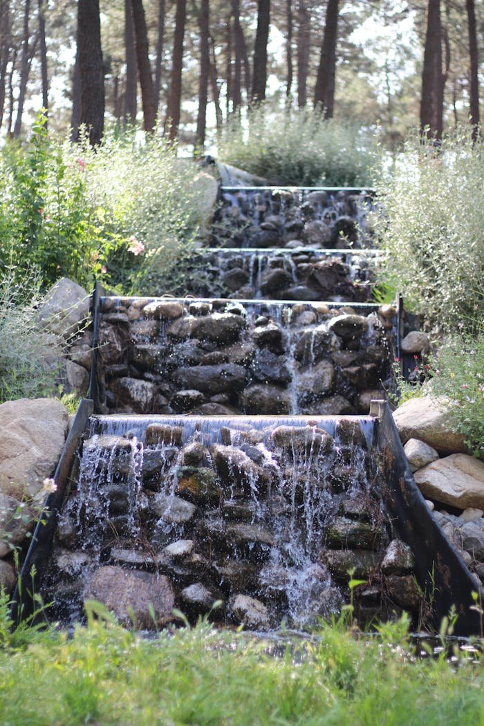 Tranquil cascading waterfall in a lush forest garden, perfect for relaxation themes.